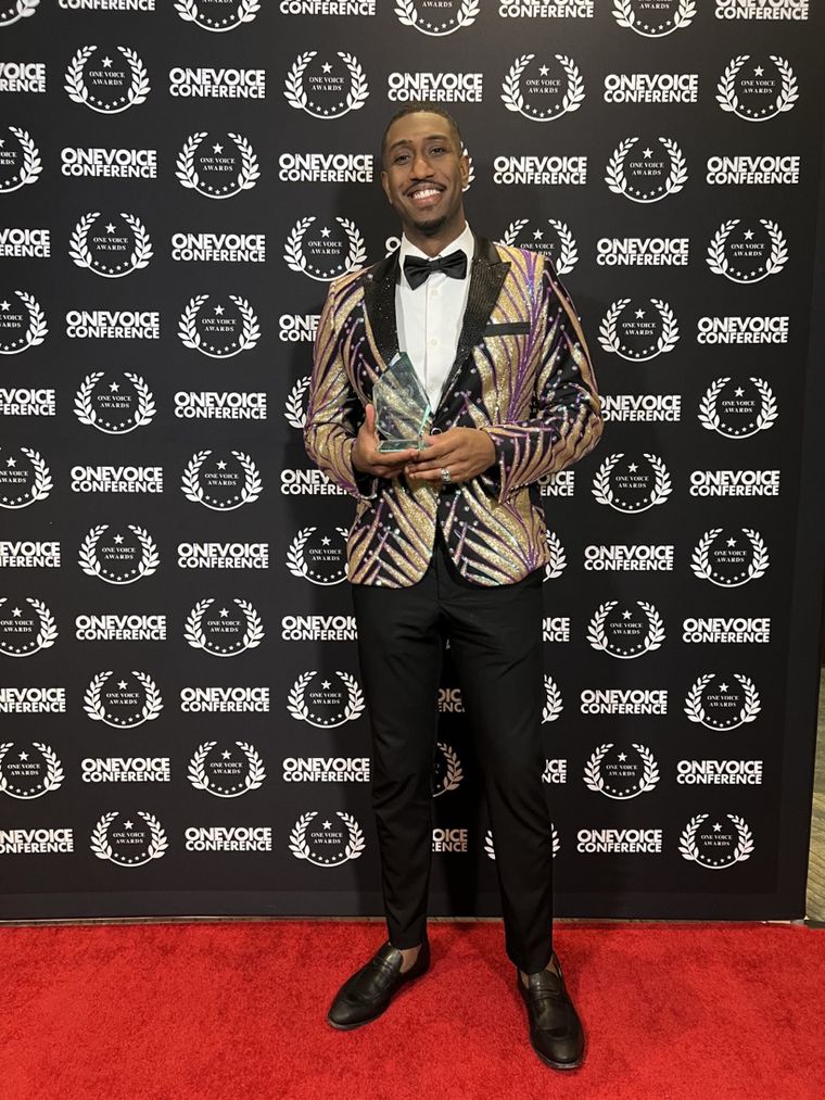 The voice behind New Majority Voice holding a One Voice Award